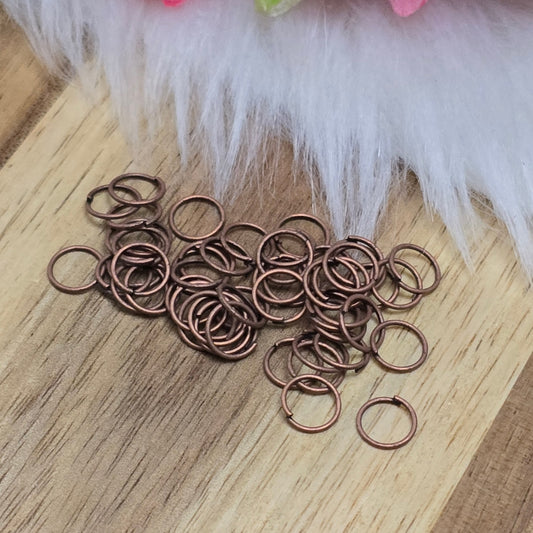 Das Bild zeigt 50 offene Biegeringe in antik kupferfarbig mit einem Durchmesser von 6mm. Die Verbindungsringe sind ein unverzichtbares Zubehör für die Schmuckherstellung. Ideal um Charms und Verschlüsse zuverlässig zu befestigen.