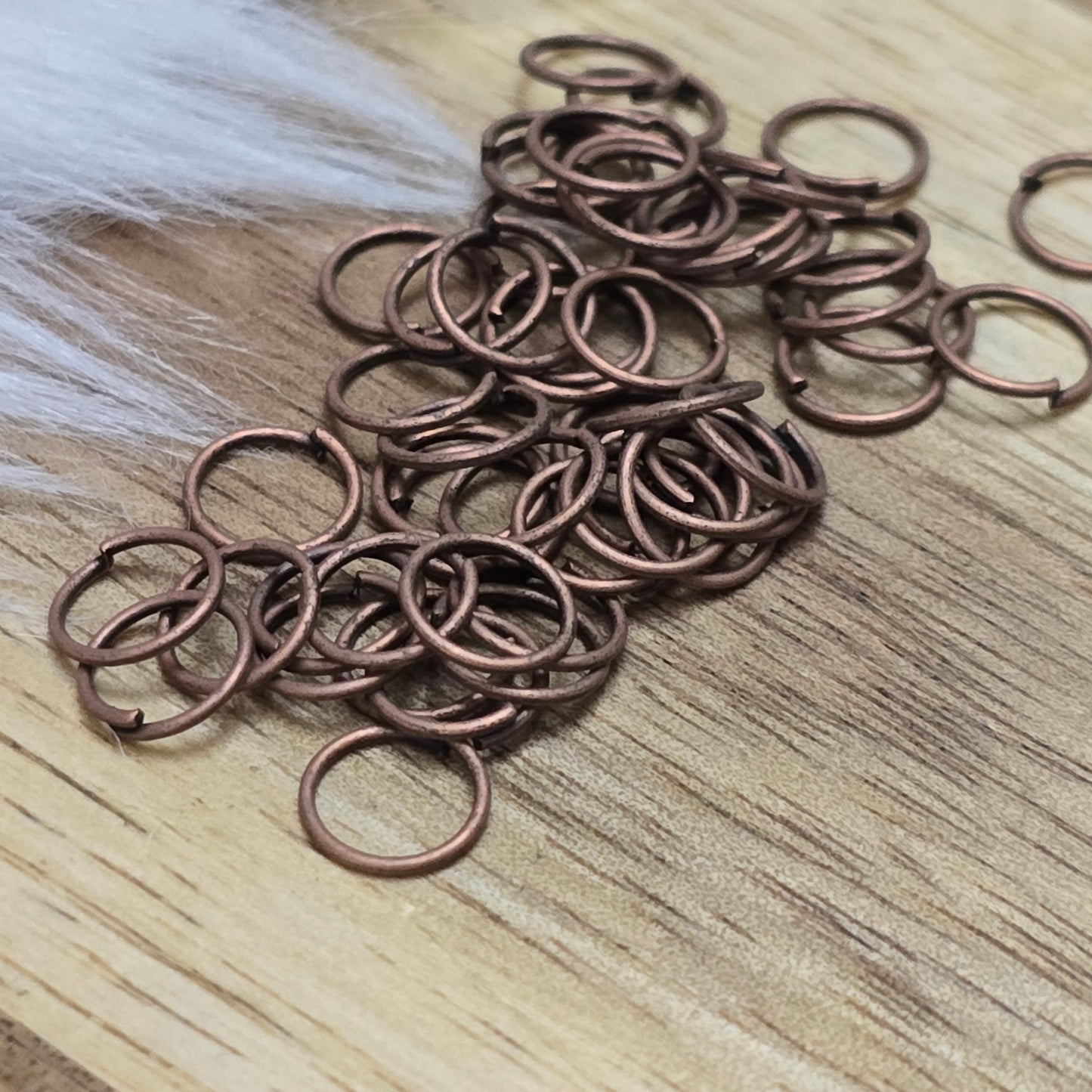 Das Bild zeigt 50 offene Biegeringe in antik kupferfarbig mit einem Durchmesser von 6mm. Die Verbindungsringe sind ein unverzichtbares Zubehör für die Schmuckherstellung. Ideal um Charms und Verschlüsse zuverlässig zu befestigen.