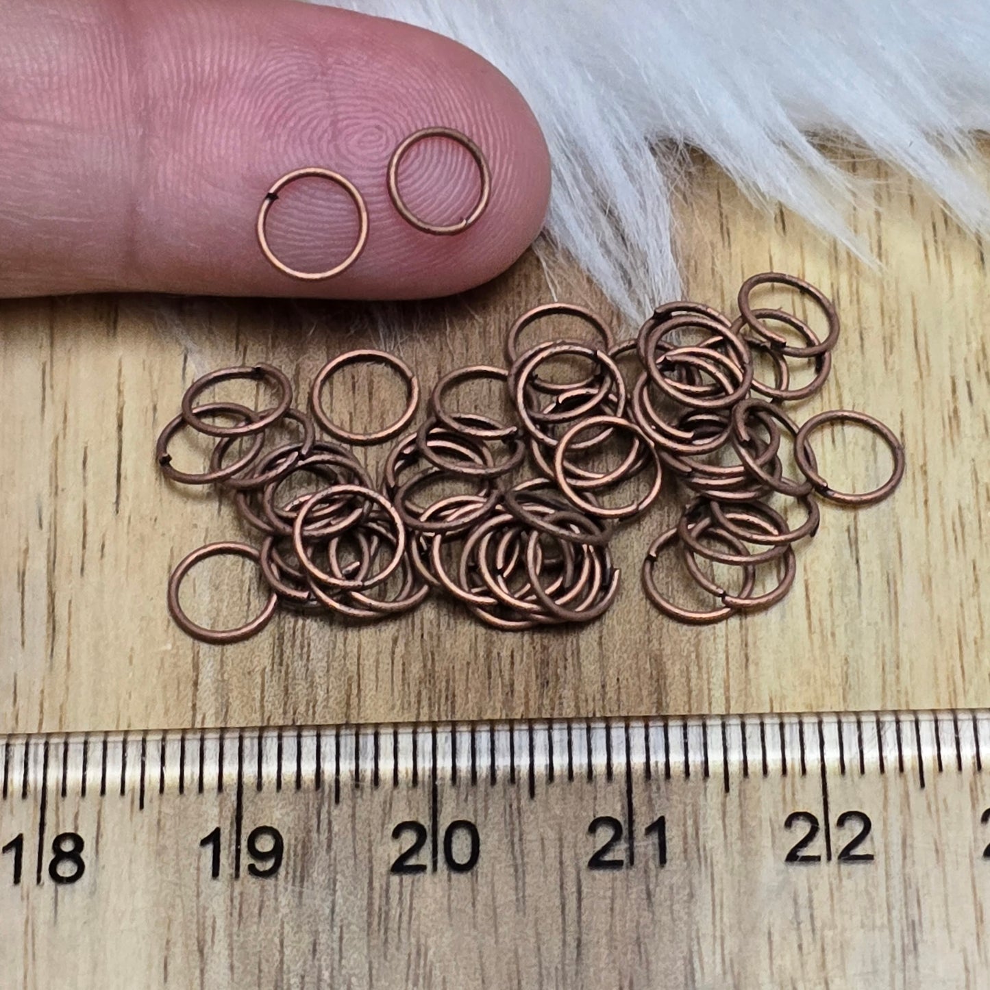 Das Bild zeigt 50 offene Biegeringe in antik kupferfarbig mit einem Durchmesser von 6mm. Die Verbindungsringe sind ein unverzichtbares Zubehör für die Schmuckherstellung. Ideal um Charms und Verschlüsse zuverlässig zu befestigen.