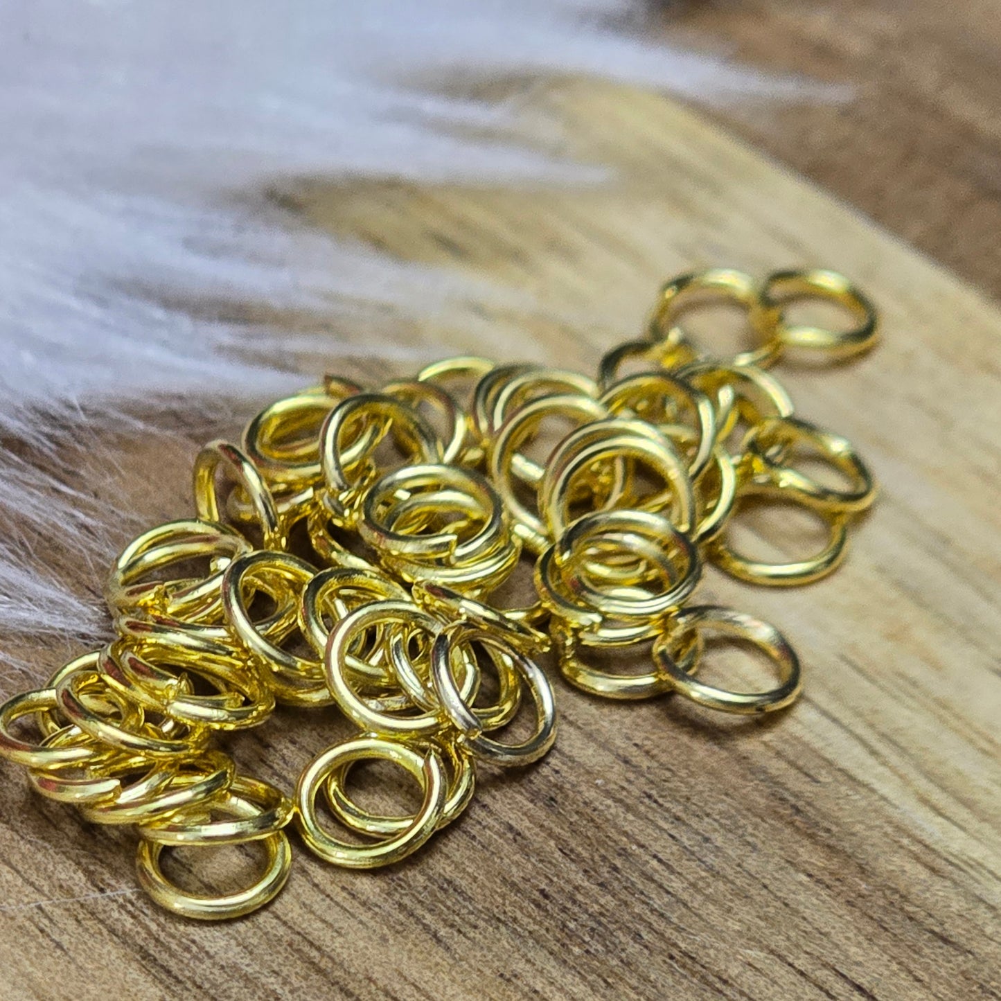 Das Bild zeigt 50 offene Biegeringe in vergoldet. Die Ringel sind ein unverzichtbares Zubehör für die Schmuckherstellung. Ideal um Charms und Verschlüsse zuverlässig zu befestigen.