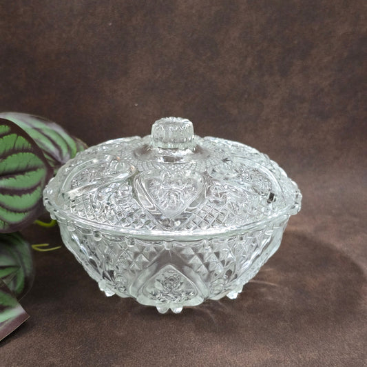 Vintage-Style Bonbonniere aus gepresstem Glas, KIG Malaysia. Schönes Relief, aber Randmacken vorhanden. Maße Ø13 cm, H9 cm, ca. 391 g. Vorsicht beim Reinigen.