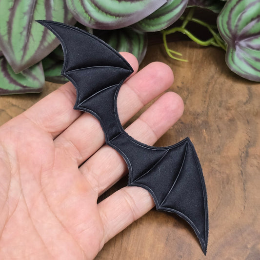 Gepolsterte Fledermausflügel-Applikation aus schwarzem Satin. 14x4 cm groß, ideal für DIY, Kostüme, Deko, Schmuck & Textilverzierung.