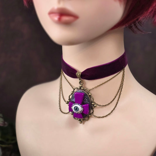 Handgefertigter Samtchoker mit invertiertem Kreuz, Auge & Strass – violett, antik-bronze, Unikat im Gothic-Stil. Für Rituale, Festivals & dunkle Seelen.