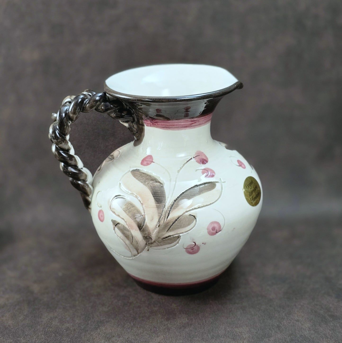 Handbemalter italienischer Keramikkrug mit floralen Ornamenten und geflochtenem Henkel, Vintage ca. 1960er–1980er Jahre.