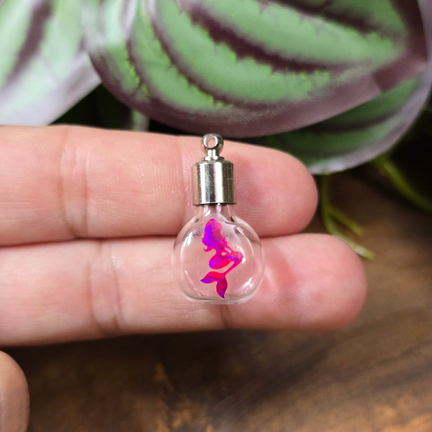 Kleine Glasflasche mit Schraubverschluss und pinkem Meerjungfrau-Motiv, ideal als Kettenanhänger und tragbare Parfümflasche.