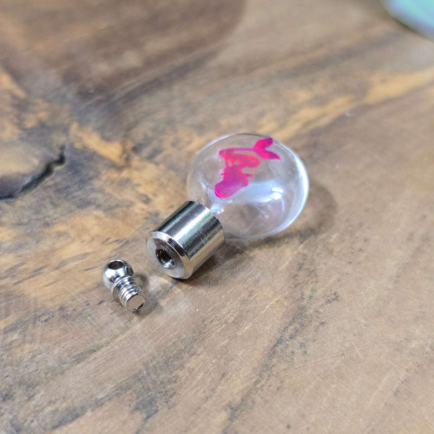 Kleine Glasflasche mit Schraubverschluss und pinkem Meerjungfrau-Motiv, ideal als Kettenanhänger und tragbare Parfümflasche.