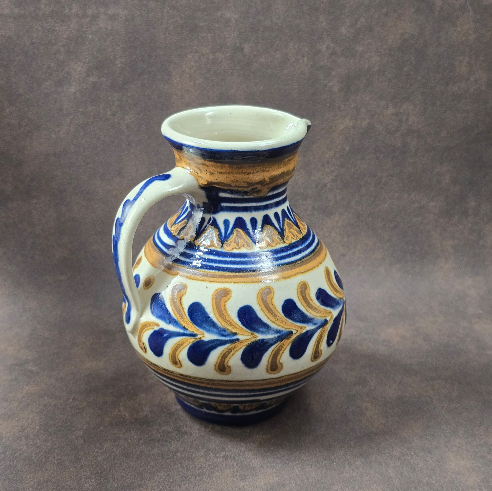 Vintage-Krug aus Lausitzer DDR-Keramik, blau-braun handbemalt, bauchige Form mit Henkel, ca. 15 cm hoch.