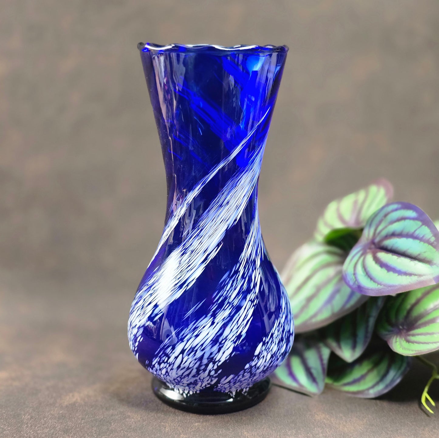 Mundgeblasene Vintage-Vase aus blauem Glas mit weißen Wirbeln, 19 cm hoch, 70er Jahre DDR. Authentisches Designobjekt mit kleinen Gebrauchsspuren.