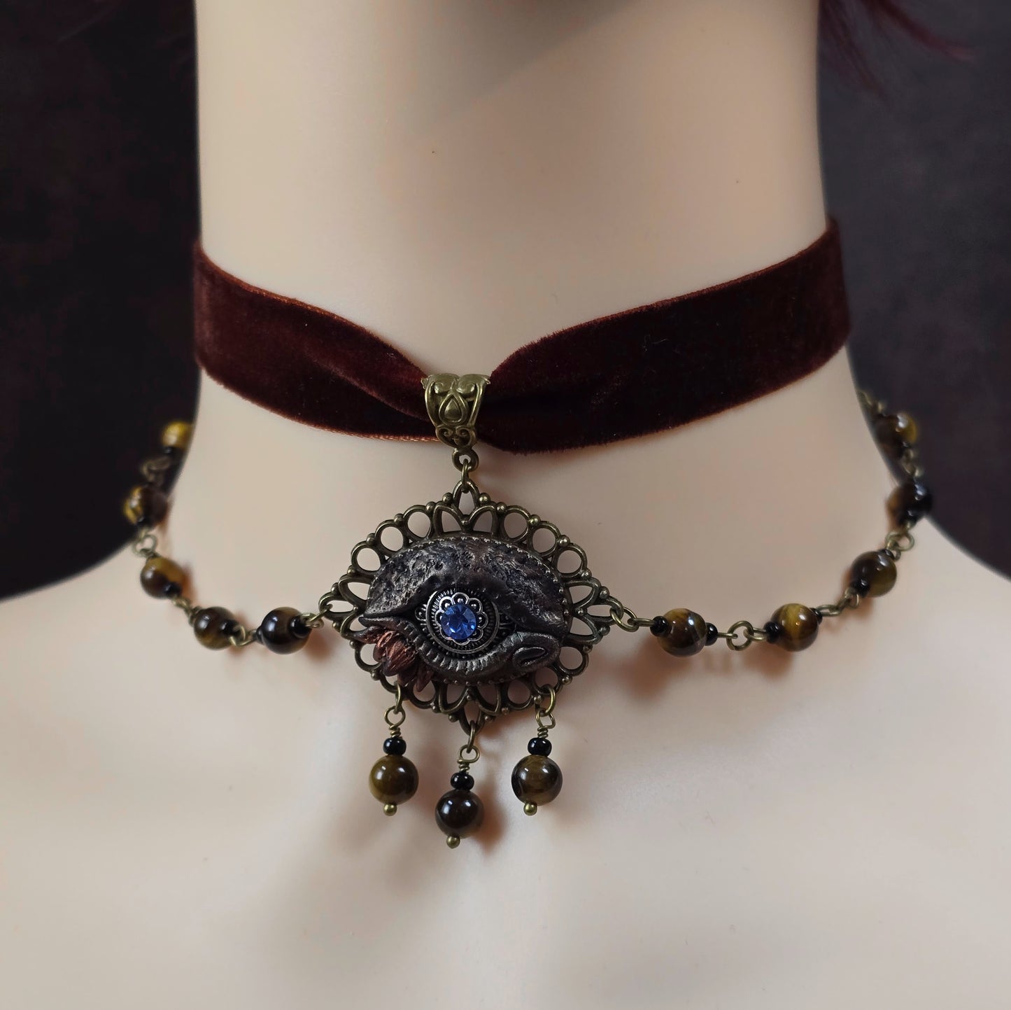 Mystischer Samtchoker in Braun mit handmodelliertem Drachenauge & Tigerauge-Perlen. Handmade Fantasy-Schmuck mit Layer-Ketten & Justierkette.