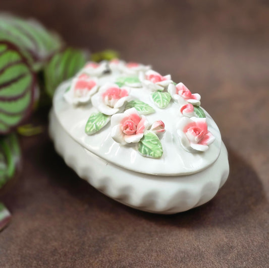 Romantische Schmuckdose aus Porzellan, weiß/rosé, 12,5×8,5×7 cm, ca. 304 g. Capodimonte-Look der 80er, ideal als Geschenk oder Deko. Ungemarkt, sehr gepflegt, bereit zum Einziehen.