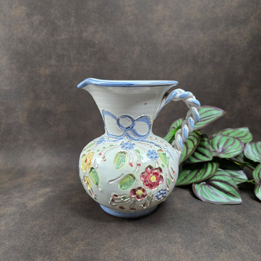 Vintage-Krug von Ainring Keramik, 1970er Jahre. Handarbeit mit Blumendekor & geflochtenem Griff. Leichte Unregelmäßigkeiten – ein echtes Unikat mit Charme!