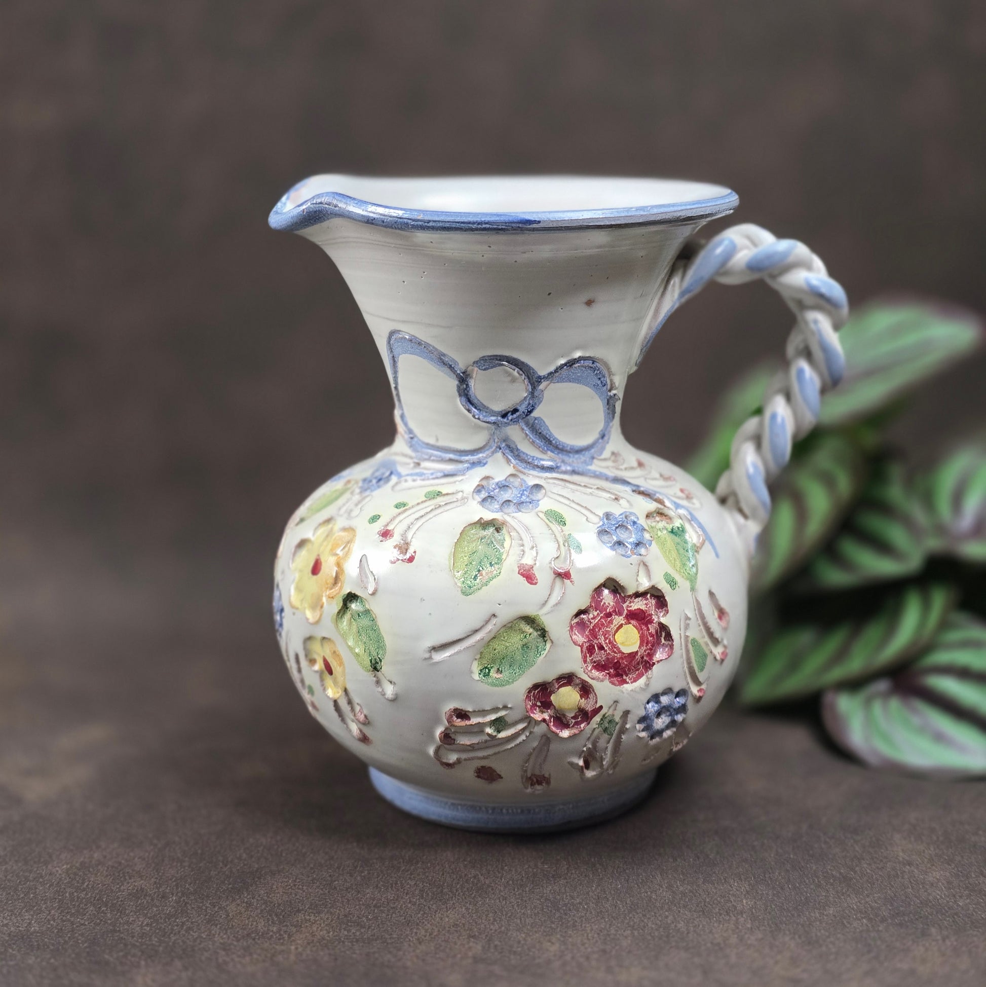 Vintage-Krug von Ainring Keramik, 1970er Jahre. Handarbeit mit Blumendekor & geflochtenem Griff. Leichte Unregelmäßigkeiten – ein echtes Unikat mit Charme!