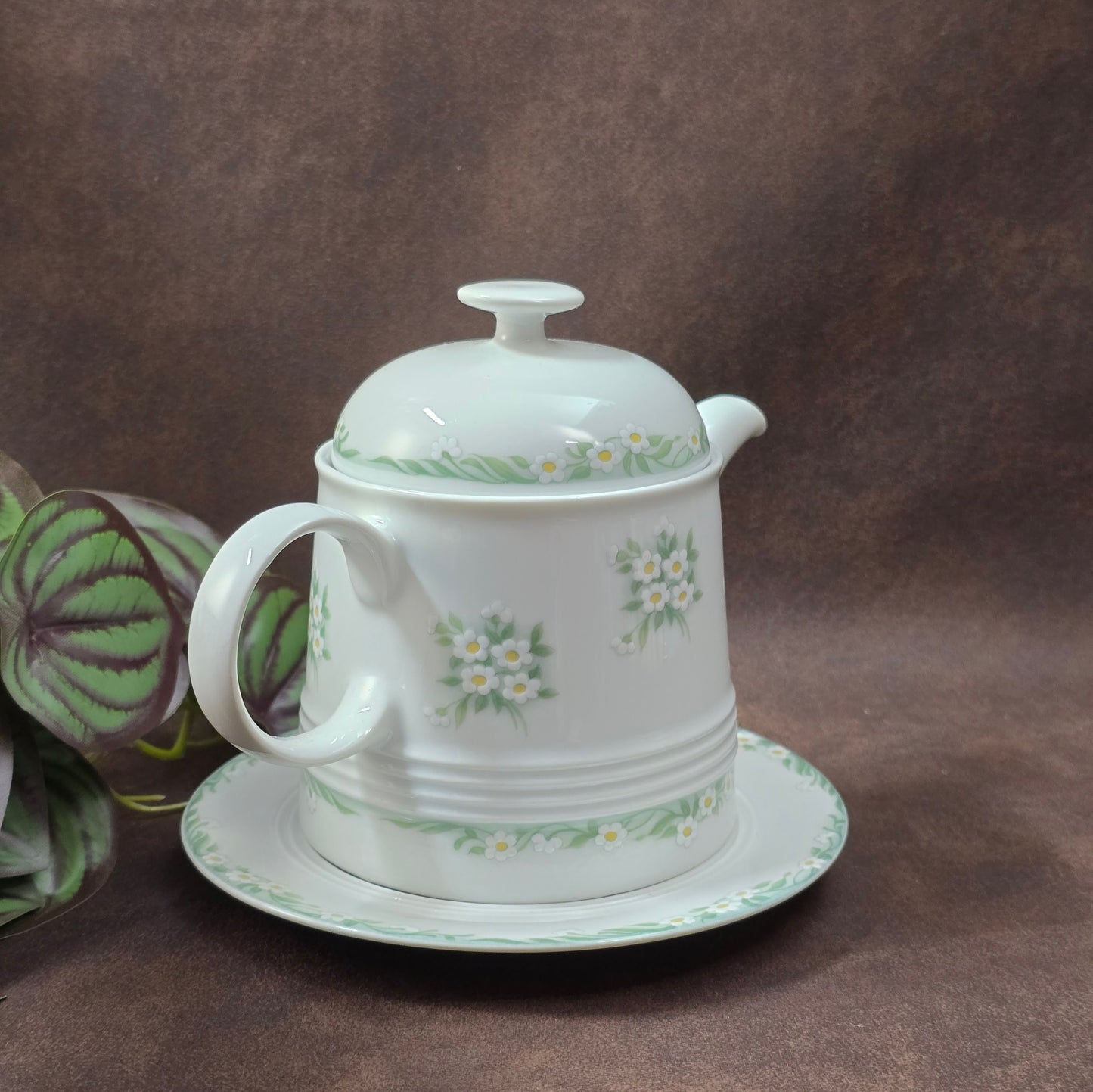 Kleine Vintage-Kaffeekanne aus Porzellan von Melitta Friesland, inkl. Teller. Fröhliches Blümchendekor, ideal für Kaffee- oder Teegenuss.