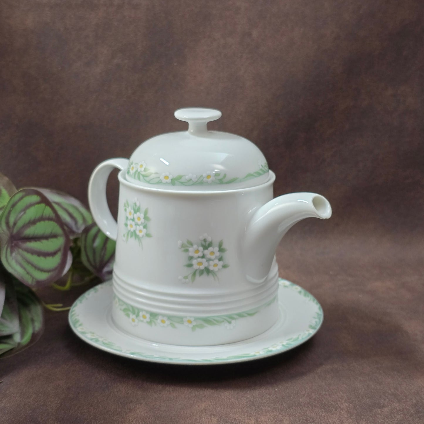 Kleine Vintage-Kaffeekanne aus Porzellan von Melitta Friesland, inkl. Teller. Fröhliches Blümchendekor, ideal für Kaffee- oder Teegenuss.