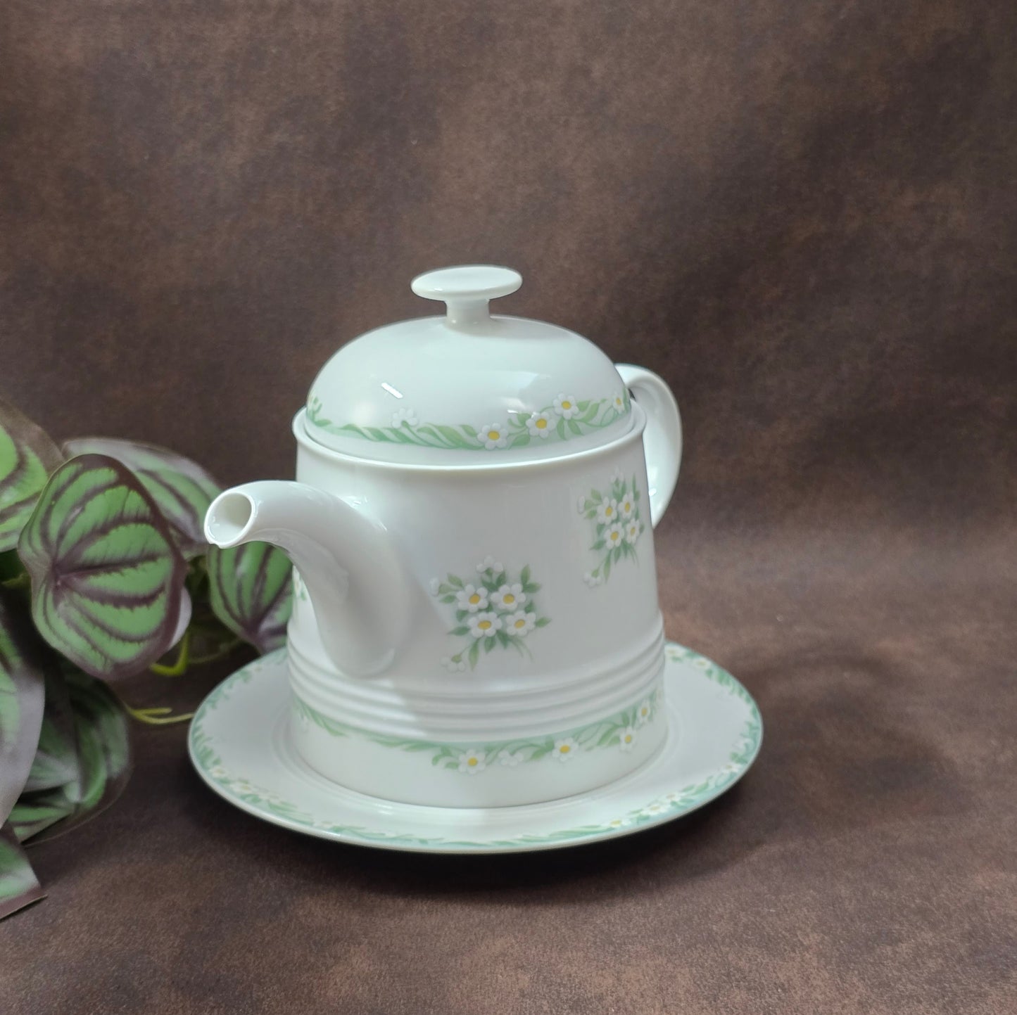 Kleine Vintage-Kaffeekanne aus Porzellan von Melitta Friesland, inkl. Teller. Fröhliches Blümchendekor, ideal für Kaffee- oder Teegenuss.
