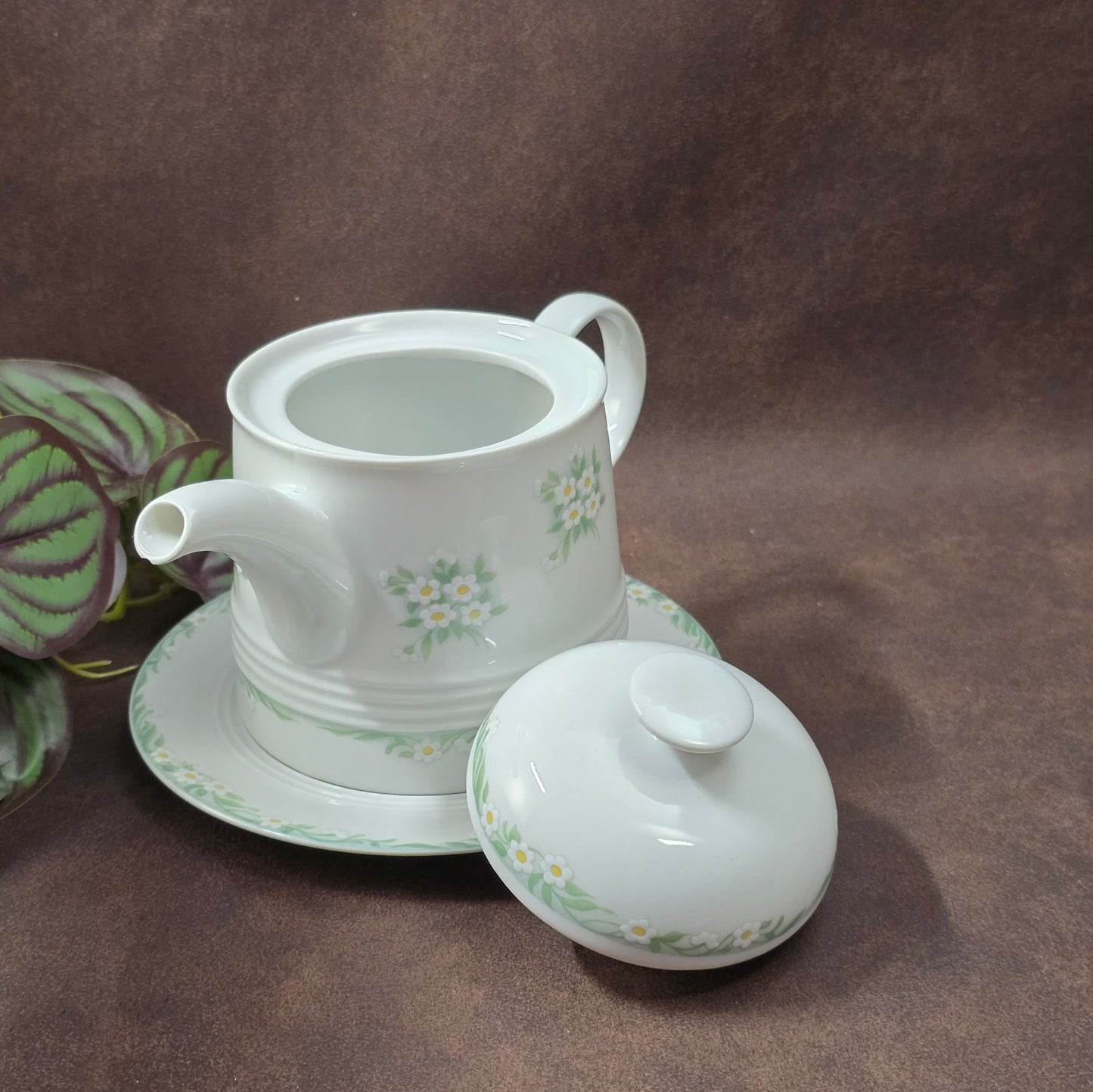 Kleine Vintage-Kaffeekanne aus Porzellan von Melitta Friesland, inkl. Teller. Fröhliches Blümchendekor, ideal für Kaffee- oder Teegenuss.