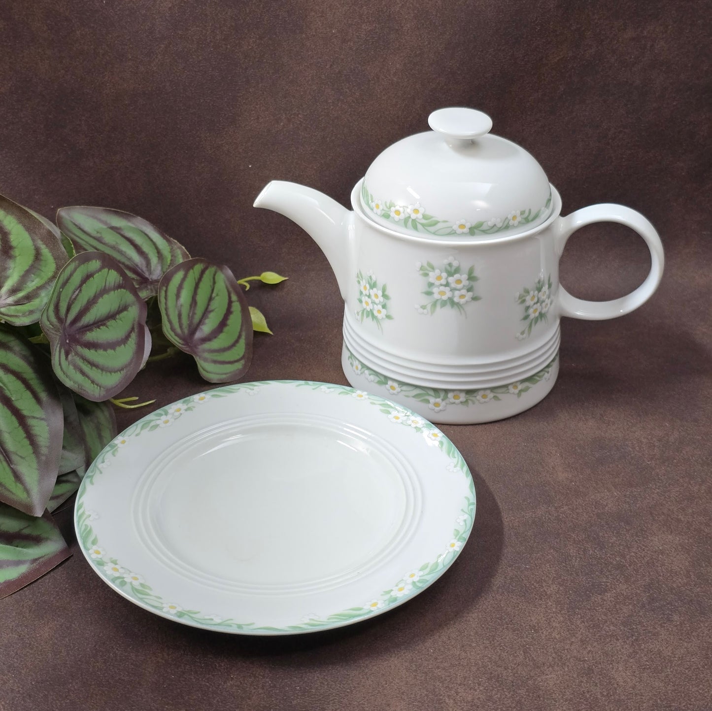 Kleine Vintage-Kaffeekanne aus Porzellan von Melitta Friesland, inkl. Teller. Fröhliches Blümchendekor, ideal für Kaffee- oder Teegenuss.