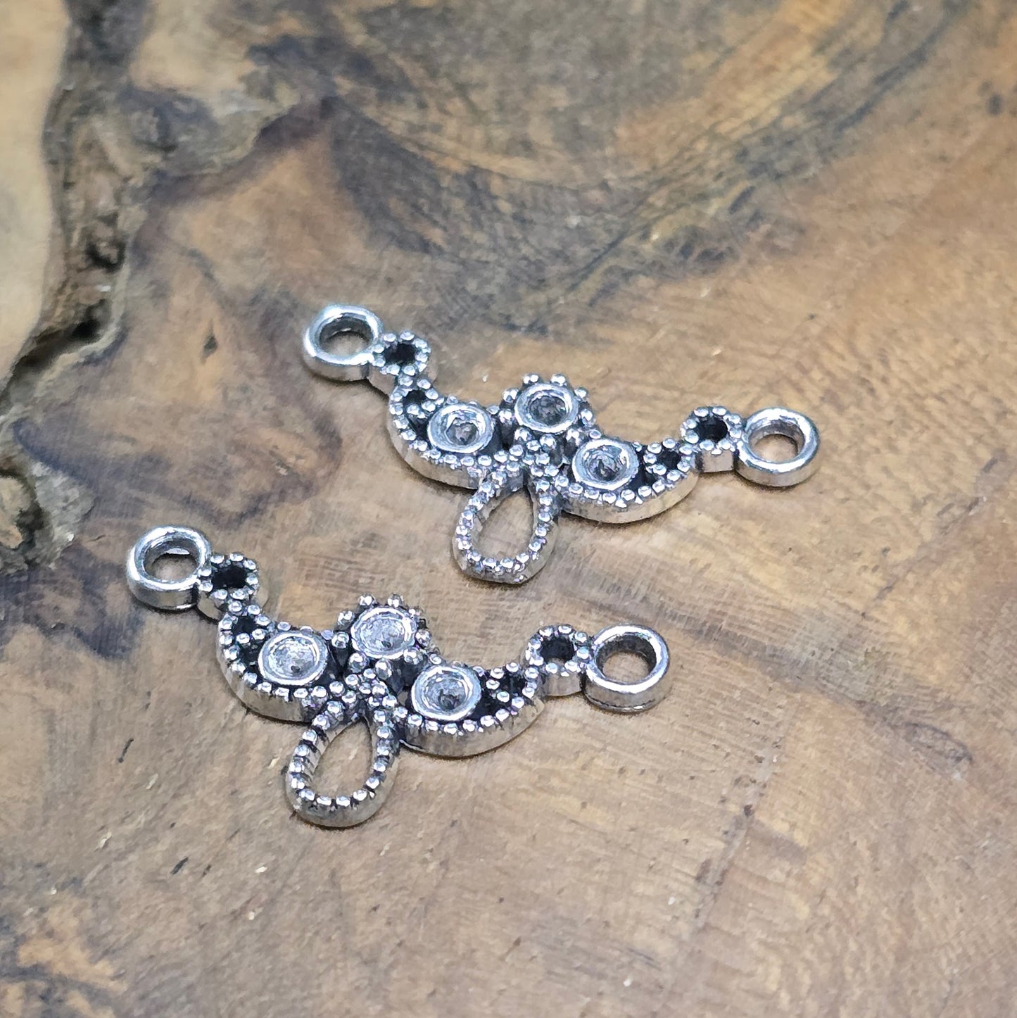 Zwei antik silberfarbene Schmuckverbinder im Bogen-Design – perfekt für DIY-Armbänder, Tiaras & mehr. Mit Mulden für Strasssteine zur individuellen Gestaltung.