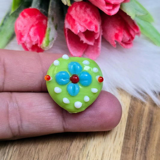 Zwei grüne Herzperlen mit Blumen und Bumps – handgefertigt in Indien. Ideal für romantische Ketten, Armbänder & Accessoires. Jede Perle ein Unikat!