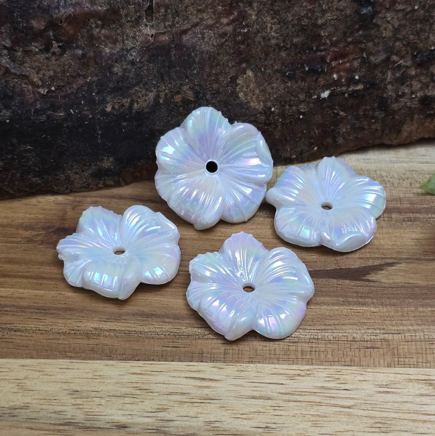Diese 12 weißen, irisierenden Blumenperlen aus Acryl mit einem Durchmesser von 22 mm sind perfekt für deine kreativen Projekte! Ideal für Schmuck, Makramee und Dekorationen. Ihre schimmernde Oberfläche bringt blumigen Flair und ist eine wunderbare Ergänzung für Hochzeiten, Sommerfeste und andere festliche Anlässe.