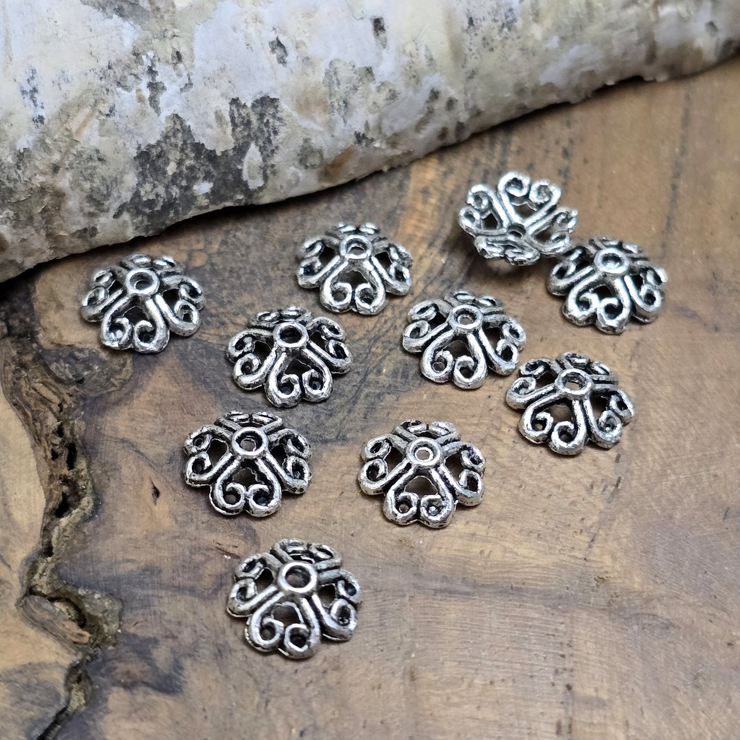 20 filigrane Perlenkappen in antik silberfarbener Optik, gestaltet in Form von Blumen oder Kleeblättern. Perfekt zum Verzieren und Schützen von Perlen und zur Veredelung von Schmuckstücken.