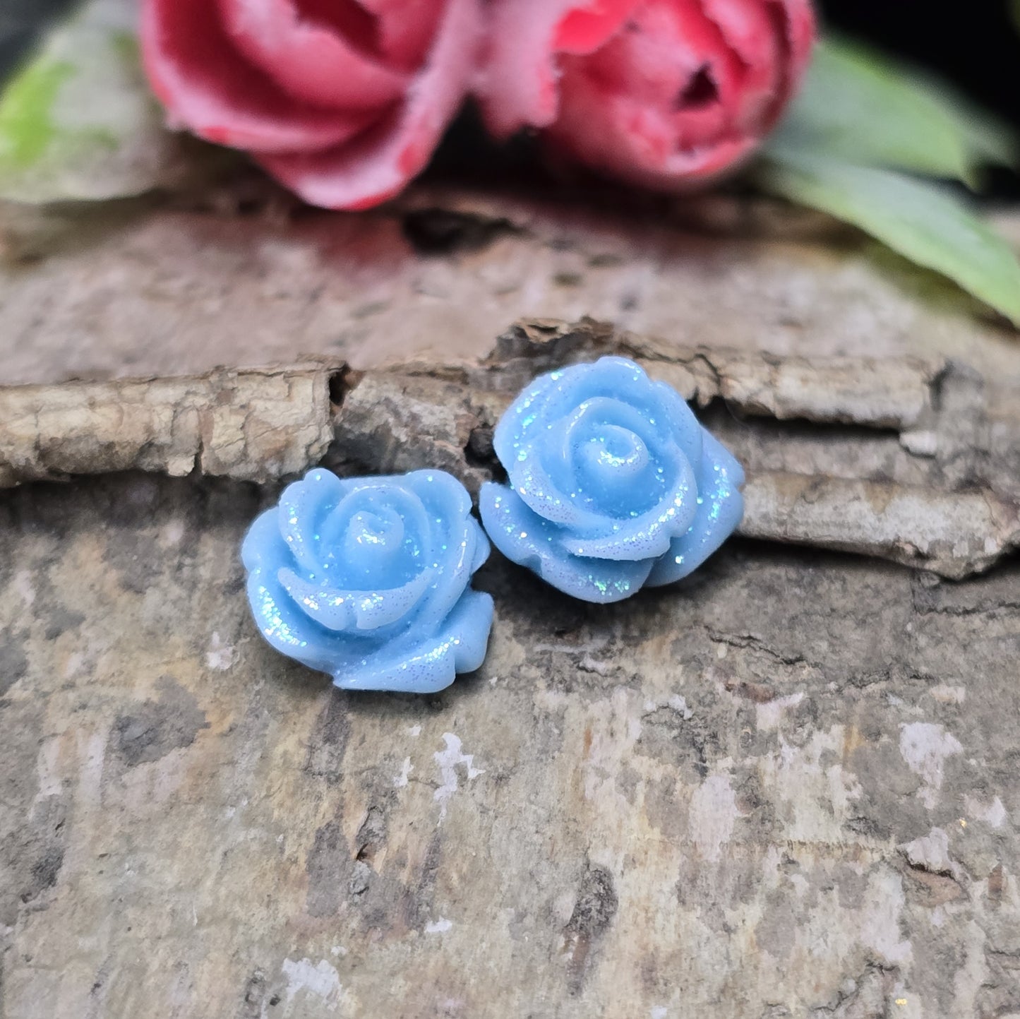 Das Bild zeigt glitzernde Röschen aus Resin – 11mm – Blau – Elegante Blütenpracht für deine Schmuckkreationen ✨🌊