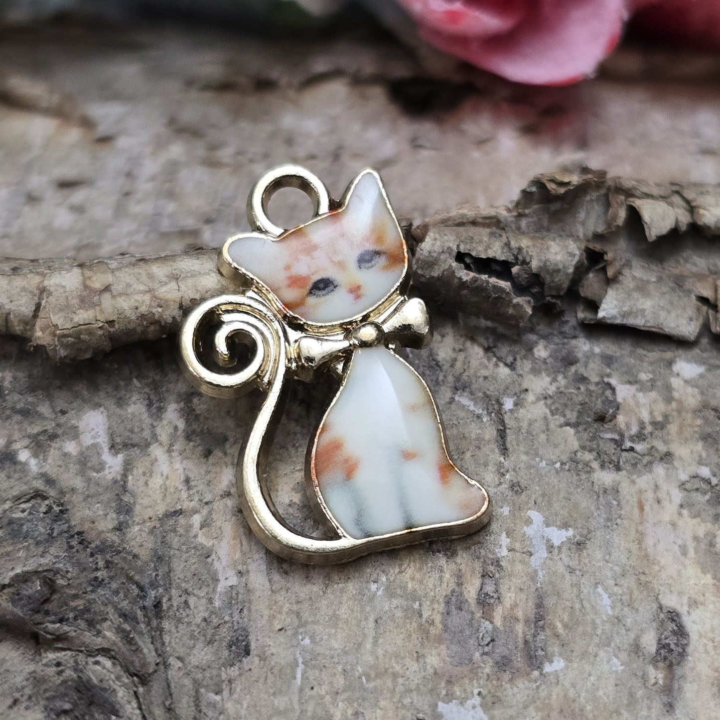 Das Bild zeigt einen goldfarbenen Anhänger mit einer rot getigerten Katze. Die Katze ist detailliert mit einem auffälligen rot-getigerten Fellmuster dargestellt, das dem Anhänger eine lebendige und energiegeladene Ausstrahlung verleiht. Der Anhänger hat eine elegante goldfarbene Umrandung, die das Design zusätzlich betont. Mit einer Größe von ca. 21mm eignet sich der Anhänger perfekt für Schmuckkreationen oder kreative DIY-Projekte.