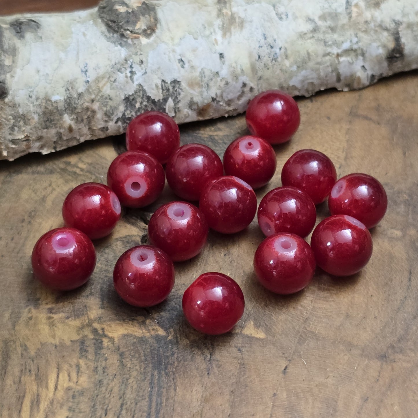Das Bild zeigt dunkelrote Glasperlen. Die Perlen eignen sich hervorragend für die Herstellung von Armbändern, Halsketten, Ohrringen oder anderen Schmuckstücken. Ob als Hauptbestandteil oder Akzent – sie fügen sich harmonisch in jede Kreation ein.