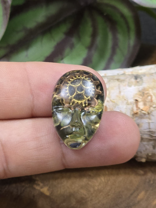 Transparenter Gesicht-Cabochon aus dunkelgrünem Resin mit eingearbeiteten Zahnrädern zur Größendarstellung