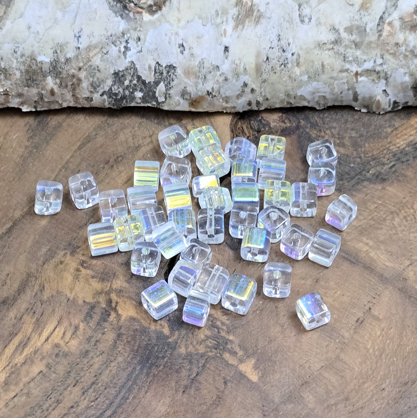 Das Bild zeigt 40 kleine Glasperlen – Würfelform – Crystal AB – 4mm – Funkelnde Eleganz für deine Schmuckkreationen