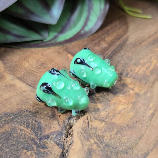 2 handgefertigte Lampwork-Glasperlen in Tropfenform, grün mit schwarzem Dekor. Einzigartiges Material mit Noppen für kreative Schmuckherstellung.