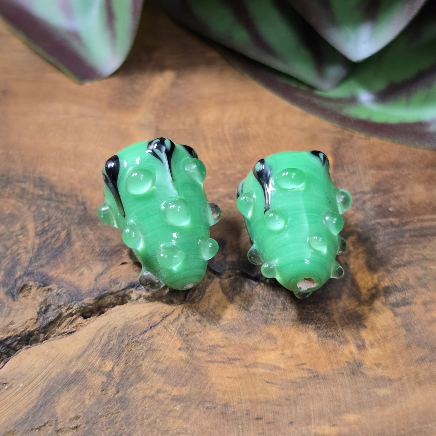 2 handgefertigte Lampwork-Glasperlen in Tropfenform, grün mit schwarzem Dekor. Einzigartiges Material mit Noppen für kreative Schmuckherstellung.