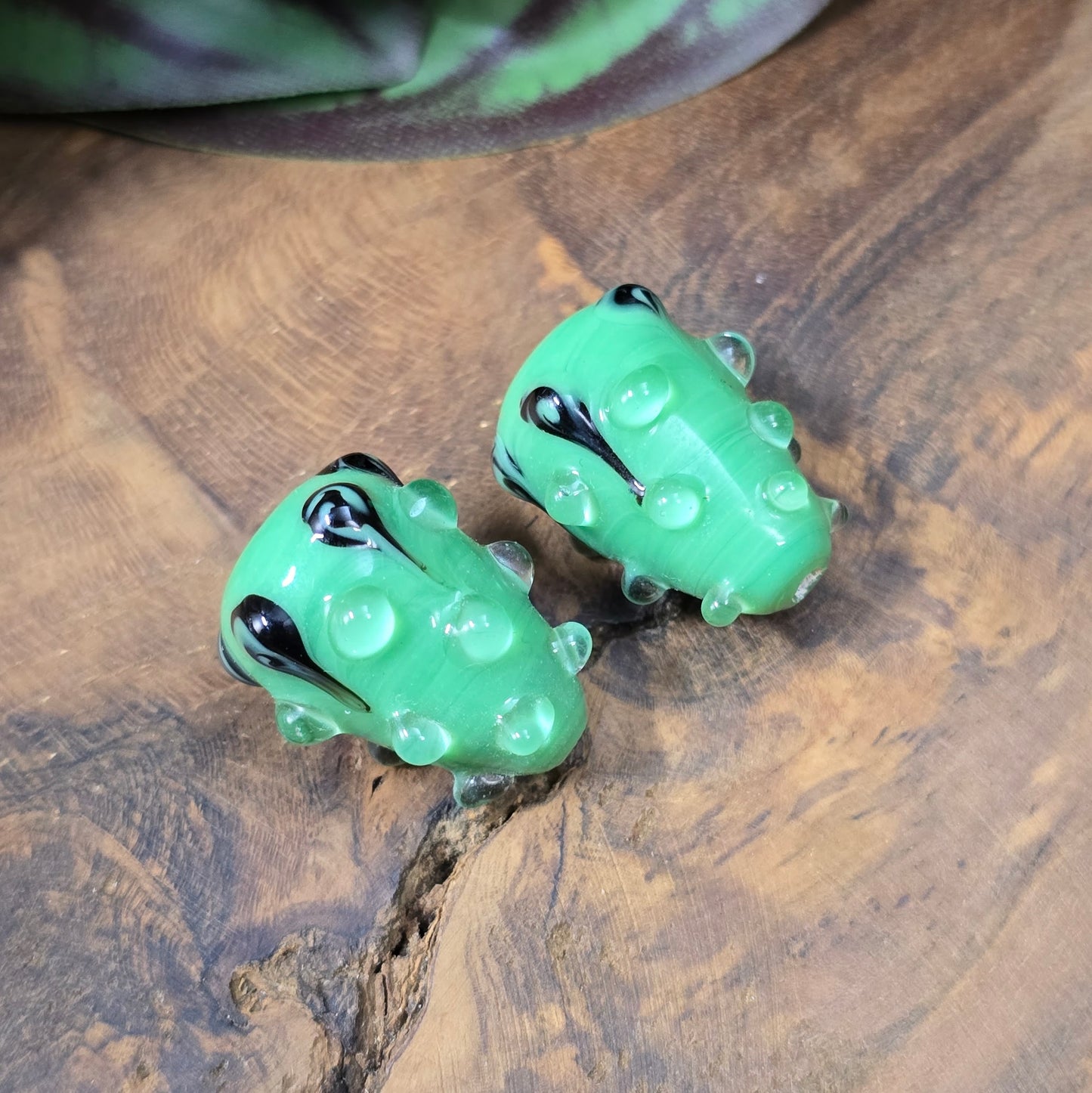 2 handgefertigte Lampwork-Glasperlen in Tropfenform, grün mit schwarzem Dekor. Einzigartiges Material mit Noppen für kreative Schmuckherstellung.
