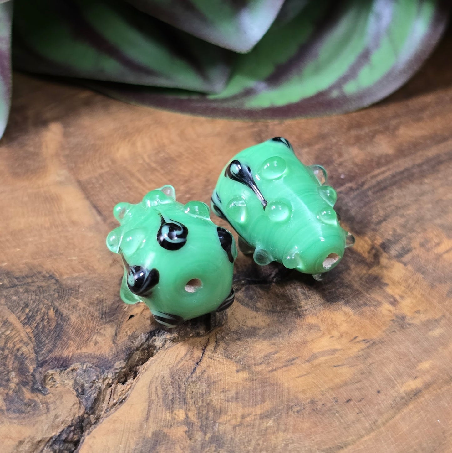 2 handgefertigte Lampwork-Glasperlen in Tropfenform, grün mit schwarzem Dekor. Einzigartiges Material mit Noppen für kreative Schmuckherstellung.