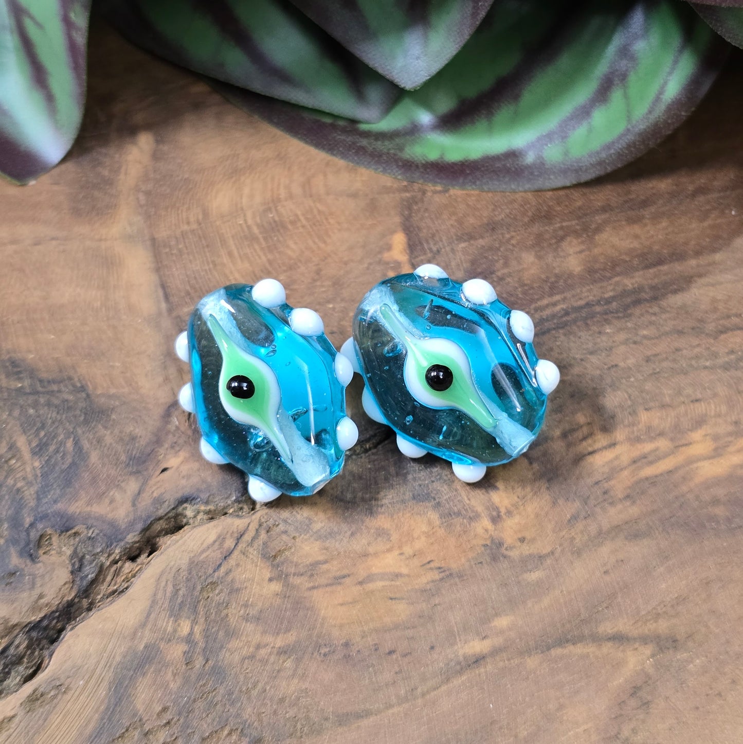 2 handgefertigte Lampwork-Glasperlen in Blau, Oval mit Noppen & Augenmotiv. Einzigartiges Material für kreative Schmuckherstellung.