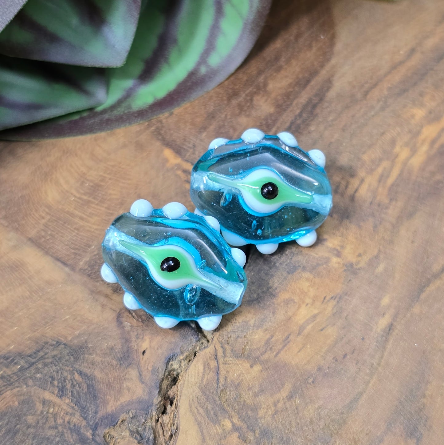2 handgefertigte Lampwork-Glasperlen in Blau, Oval mit Noppen & Augenmotiv. Einzigartiges Material für kreative Schmuckherstellung.