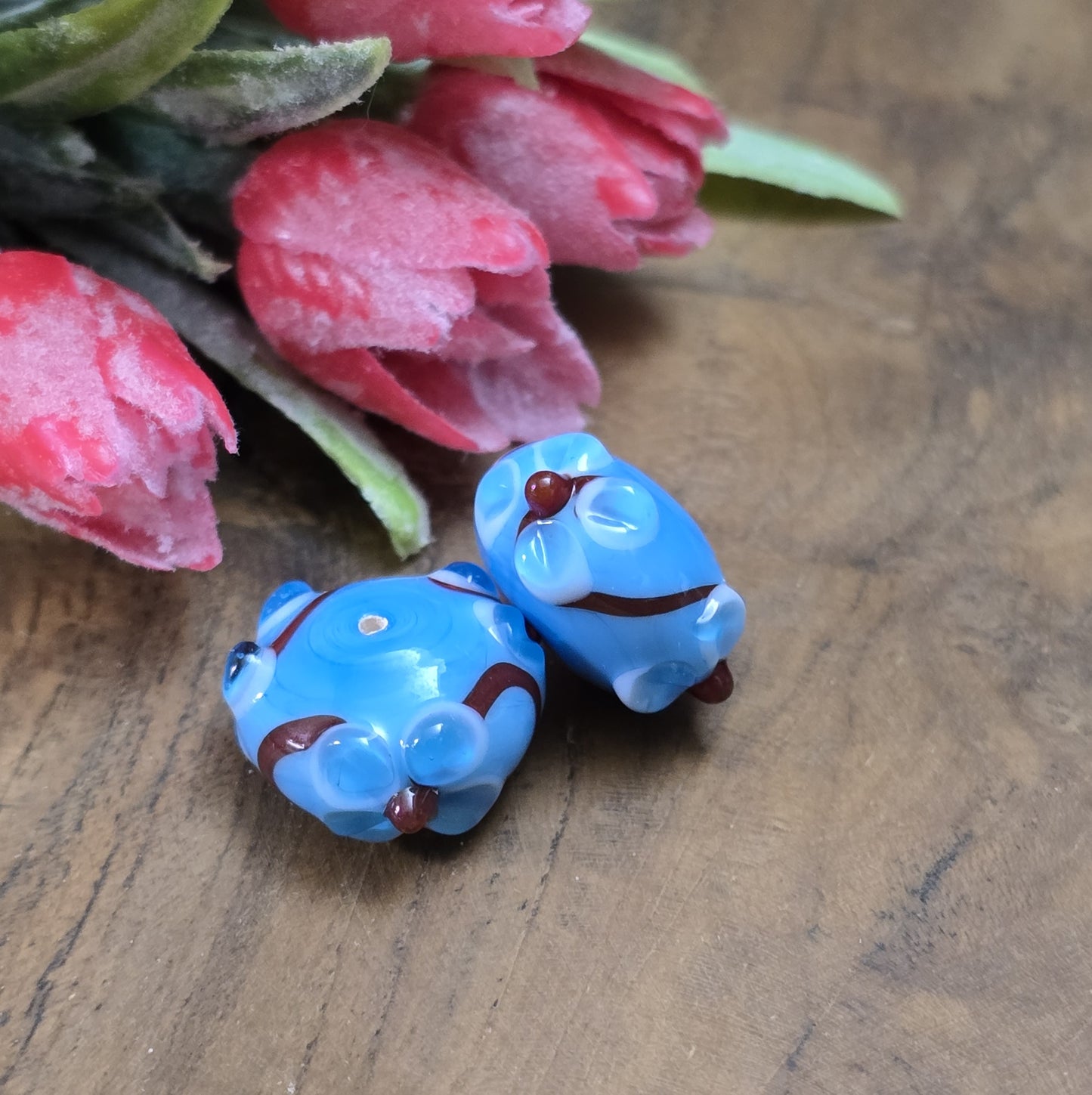 2 Handgemachte indische Glasperlen mit 3D-Blumenmuster – Blau/Rot/Weiß
Diese zauberhaften Glasperlen werden in sorgfältiger Handarbeit gefertigt und bestechen durch ihr filigranes 3D-Blumenmuster. Jede Perle ist ein Unikat und bringt einen Hauch traditioneller Handwerkskunst in deine Kreationen.