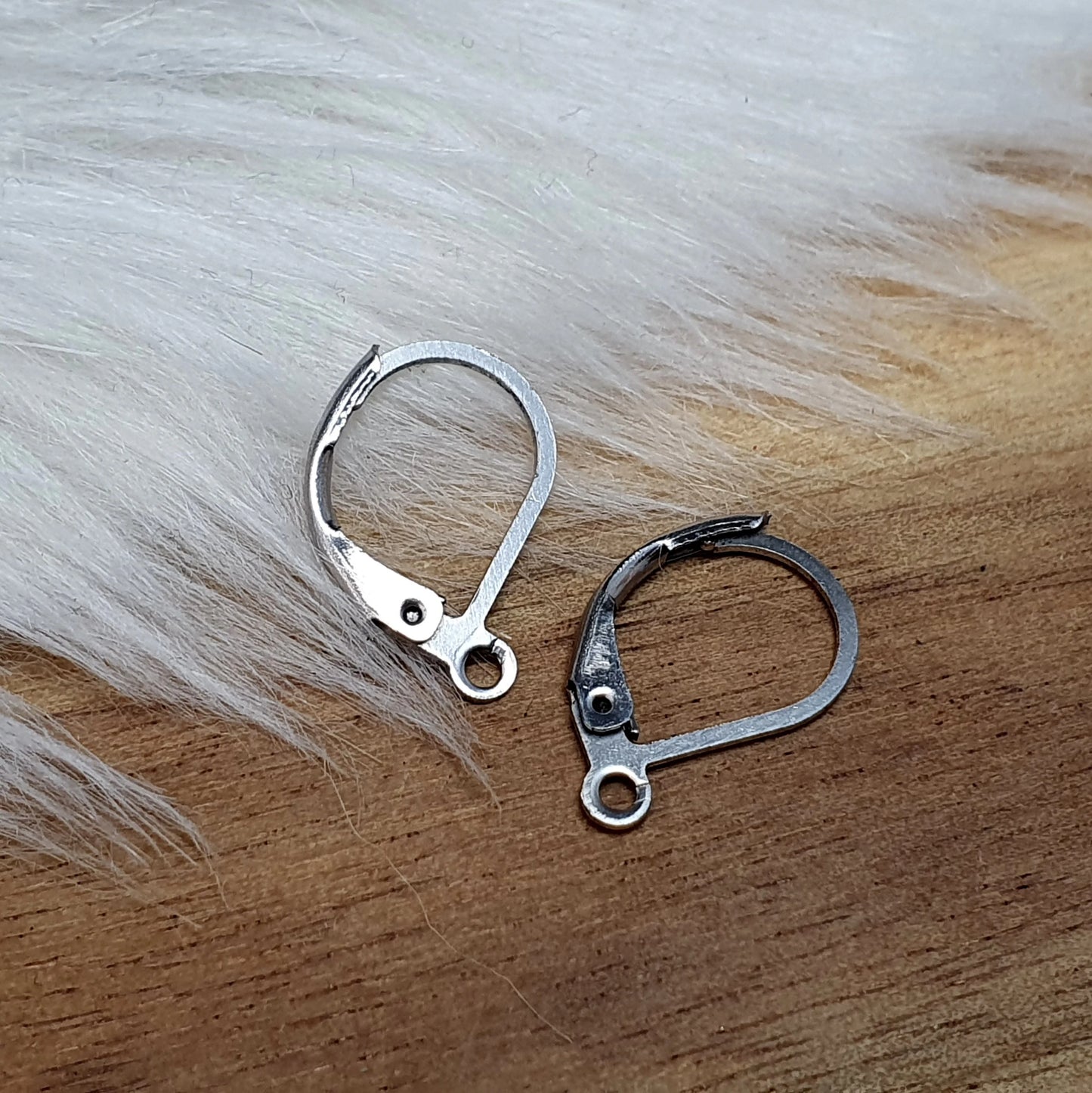 Das Bild zeigt Klappbrisuren. Jede Brisur hat eine kompakte Größe von etwa 16 x 10 mm und weist eine kleine Öse auf, die es ermöglicht, Anhänger oder andere Schmuckelemente daran zu befestigen. Die Brisuren sind so gestaltet, dass sie durch eine praktische Klappmechanik leicht geöffnet und geschlossen werden können, was sie ideal für die Verwendung in individuellen Schmuckprojekten macht.