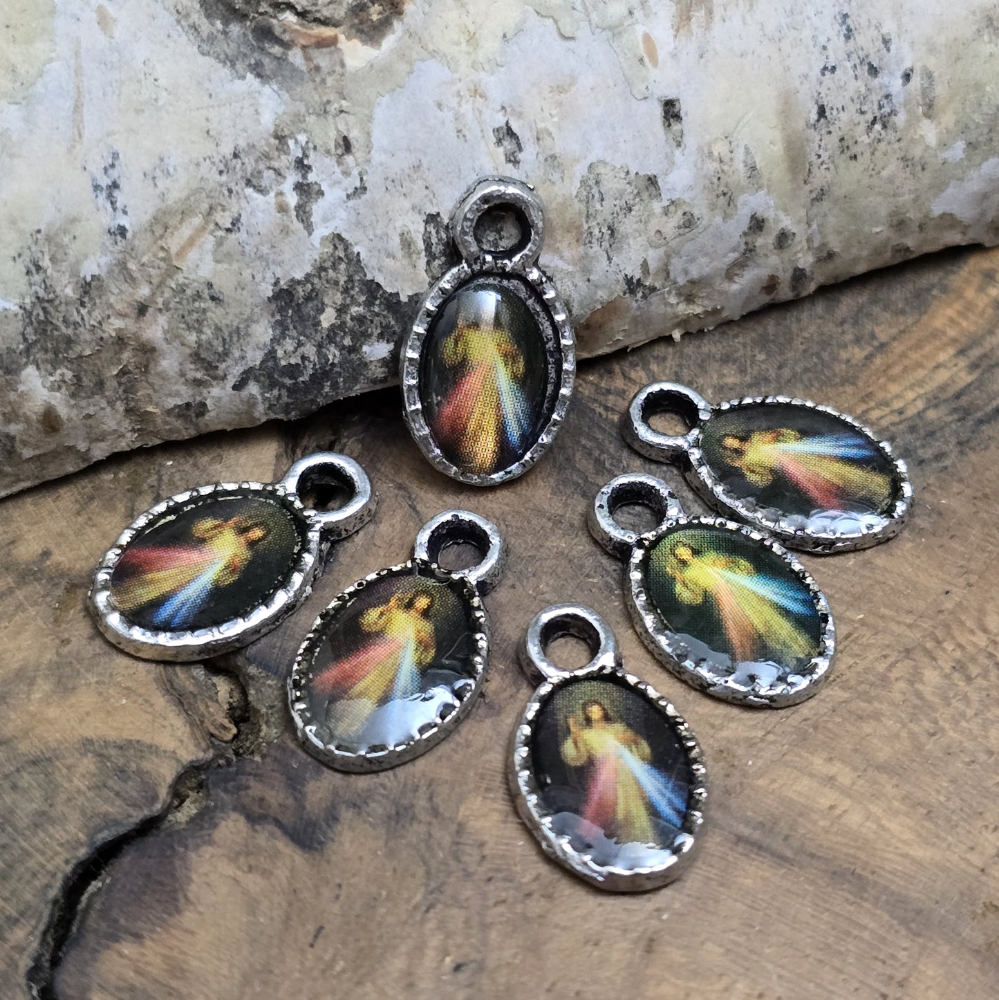 Diese kleinen Anhänger zeigen ein Bildnis von Jesus. Das Bild ist versiegelt mit Kunstharz um es vor Beschädigungen zu schützen. Auf der Rückseite befindet sich ein Kreuz. Ideal für Armbänder, Ohrschmuck und andere kreative Anwendungen. 