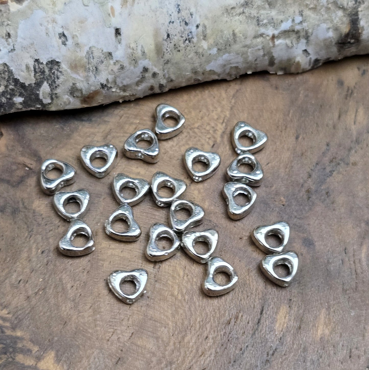 Das Bild zeigt dekorative Herzperlen mit antikem Finish, sie bringen einen charmanten und eleganten Touch in deine Schmuckkreationen. Perfekt als Abstandhalter oder zur Betonung dezent stilvoller Details.