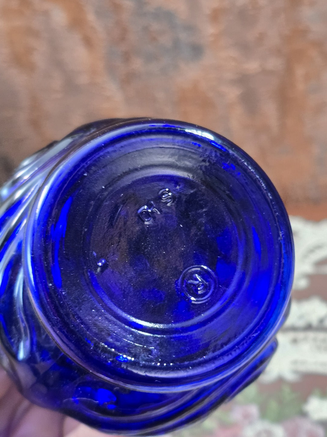 Vintage Glasflakon aus kobaltblauem Glas in Bodenansicht mit rundem Standboden und sichtbar eingeprägter Bodenkennzeichnung in Nahaufnahme