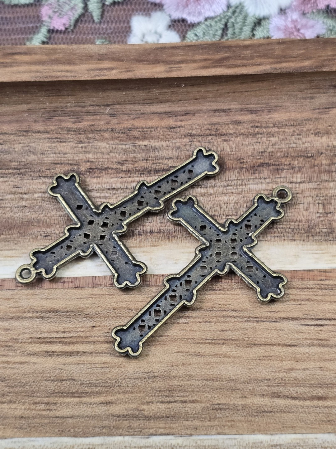 Rückseite von zwei bronze-farbenen Kreuz-Anhängern für DIY-Ketten und Schmuckherstellung.
