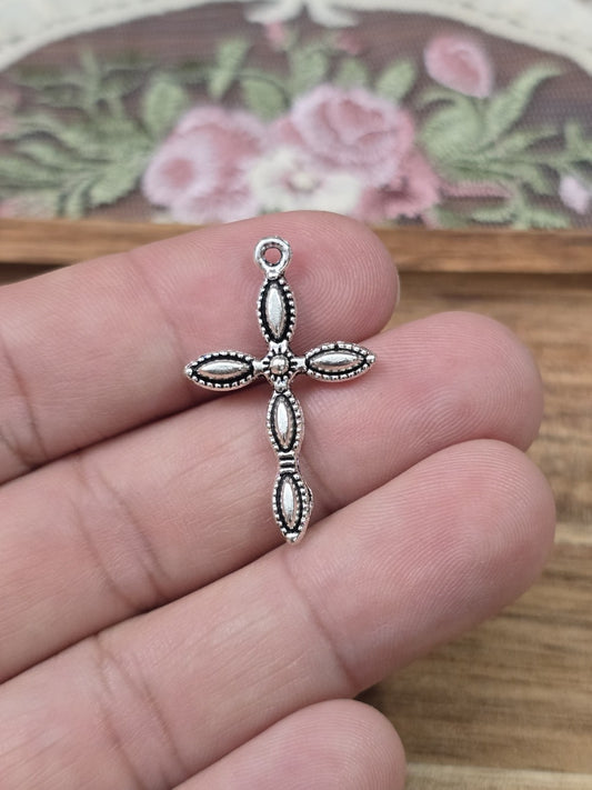 Filigraner Metall-Kreuzanhänger 29x18mm in Silber auf Hand gehalten als Größenvergleich.