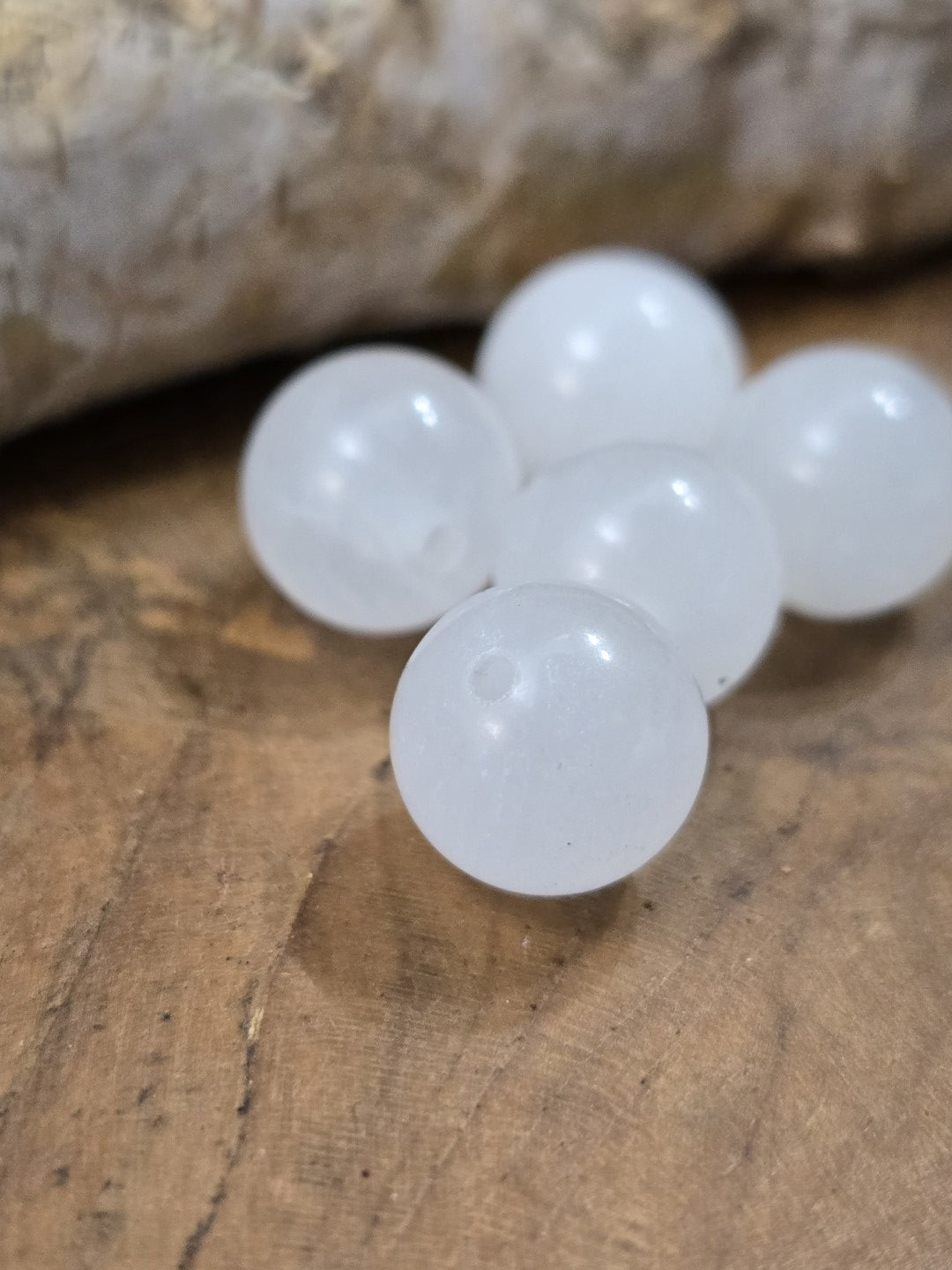 Nahaufnahme weißer Milchquarz-Perlen mit Bohrlöchern für DIY-Schmuck und Perlenarbeiten