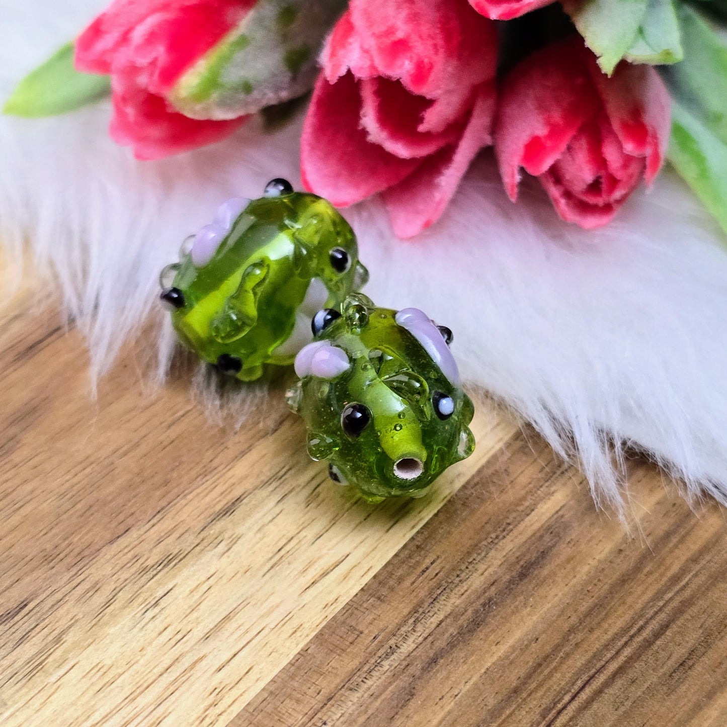 2 olivgrüne Glasperlen mit rosa & schwarzen Bumps. Handgefertigt in Indien – für auffällige DIY-Ketten, Armbänder und kreative Schmuckideen mit Struktur.