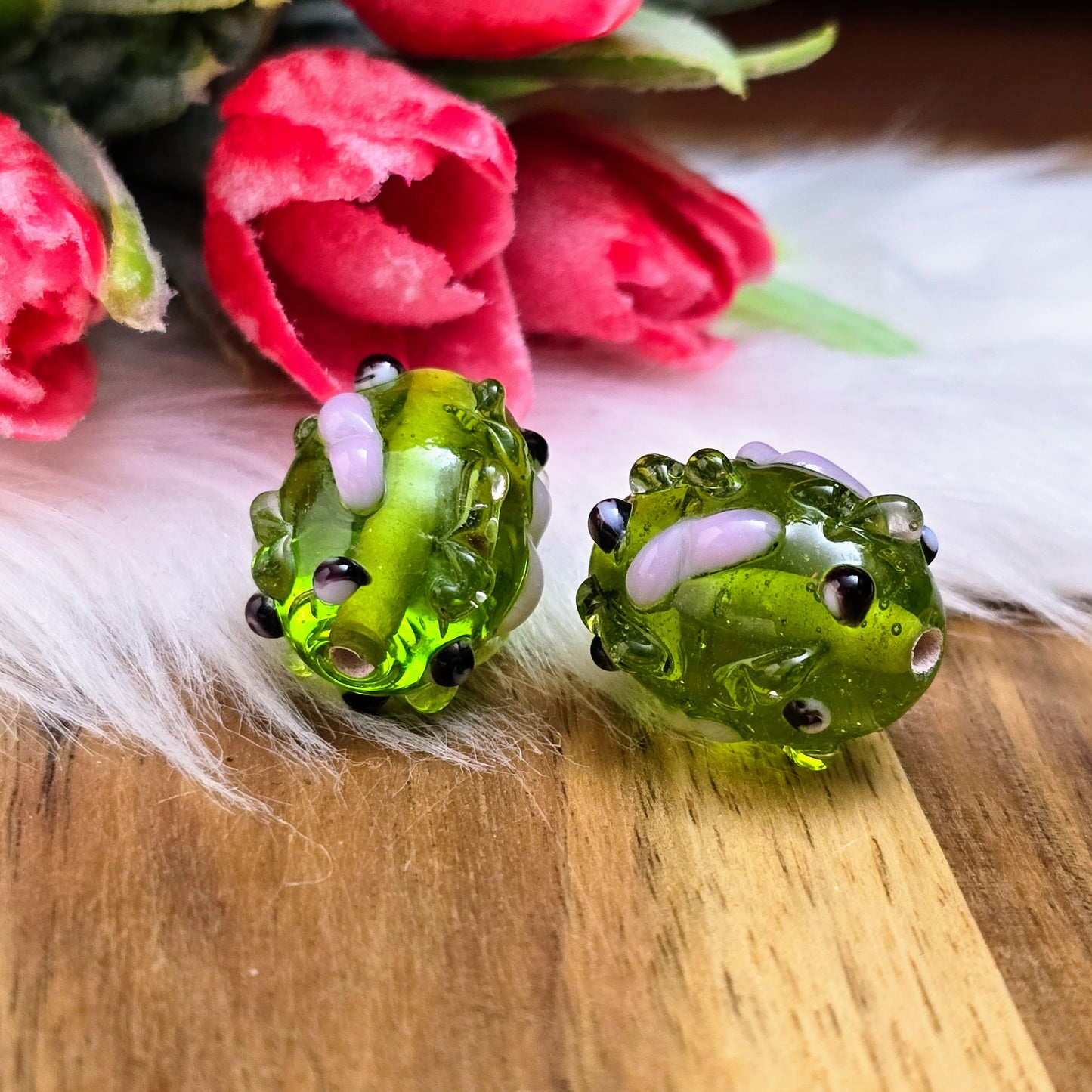 2 olivgrüne Glasperlen mit rosa & schwarzen Bumps. Handgefertigt in Indien – für auffällige DIY-Ketten, Armbänder und kreative Schmuckideen mit Struktur.