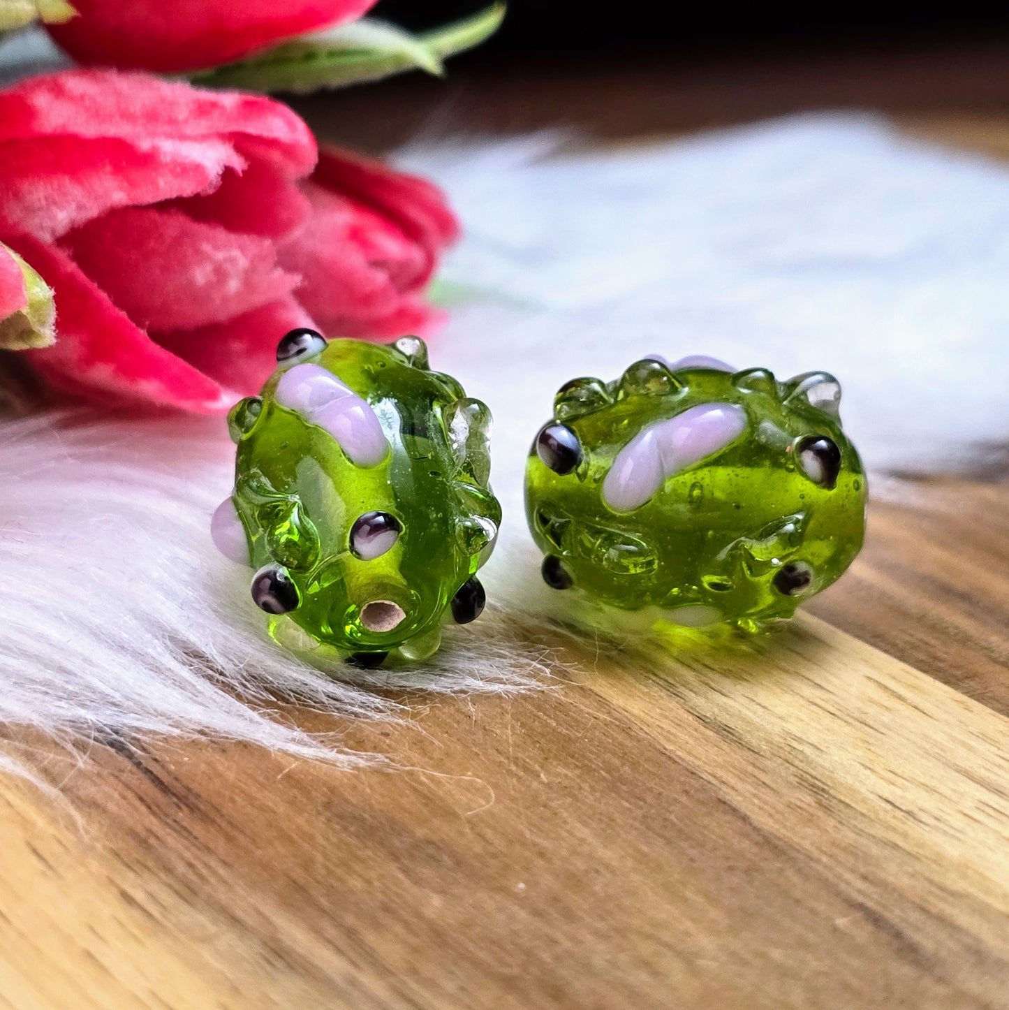 2 olivgrüne Glasperlen mit rosa & schwarzen Bumps. Handgefertigt in Indien – für auffällige DIY-Ketten, Armbänder und kreative Schmuckideen mit Struktur.
