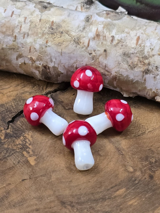 Rote und weiße Pilzperlen aus Glas mit Perlnadel als Beispiel für DIY-Schmuckverarbeitung