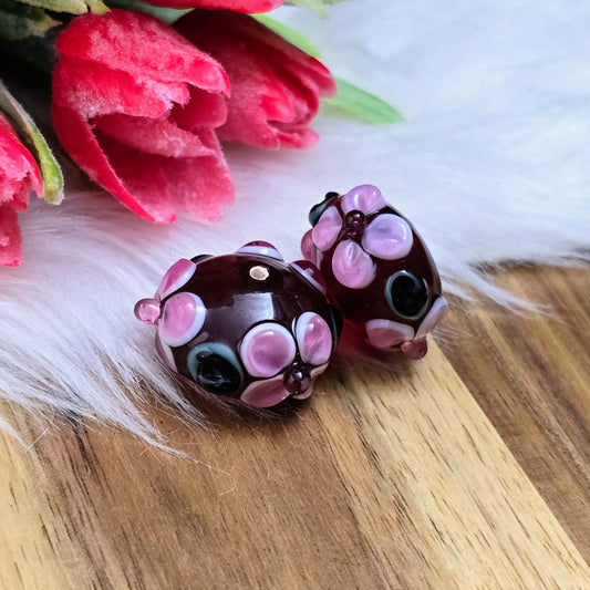 2 rote Glasperlen in Rondellform mit Bumps & Blumen in Rosa, Weiß & Grün – handgefertigt in Indien, perfekt für auffällige Schmuckstücke mit Persönlichkeit.