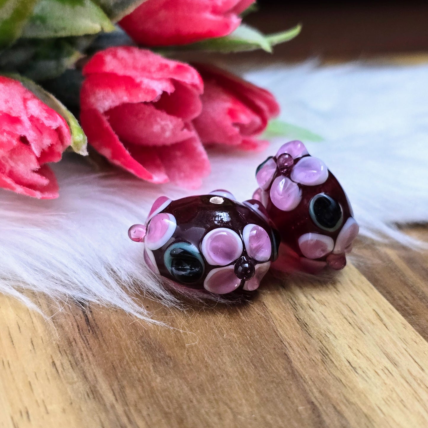 2 rote Glasperlen in Rondellform mit Bumps & Blumen in Rosa, Weiß & Grün – handgefertigt in Indien, perfekt für auffällige Schmuckstücke mit Persönlichkeit.